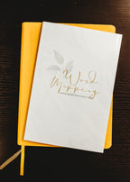 Yellow Bible sitting below a Word mapping Journal